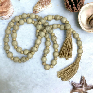 Beaded necklace with tassel on a light background with shells and starfish