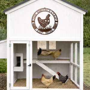 White chicken coop with a decorative metal sign featuring a rooster and the text 'The Sunny Side Coop 2023'.
