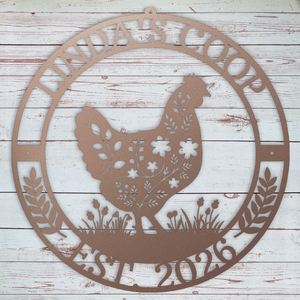 Decorative metal sign with a rooster design and text on a wooden background