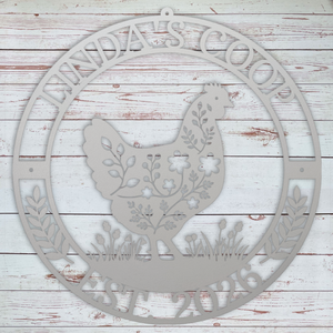 Decorative metal sign with a rooster design and 'Linda's Coop' text on a wooden background