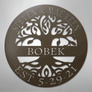 Decorative metal wall art with tree design and engraved text on a plain background