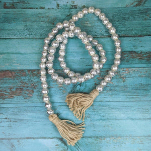 Pearl beaded necklace with tassels on a turquoise wooden background