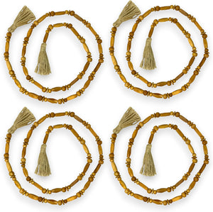 Set of four wooden beaded necklaces with tassels on a white background