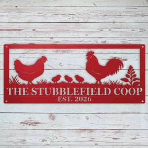 A red metal sign with a silhouette of a rooster, hen, chicks, and grass, featuring personalized name and year, displayed against a white rustic wood plank background.