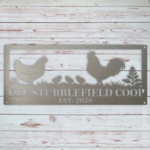 A rectangular metal sign with a rustic chicken and rooster silhouette design, featuring the text 'THE STUBBLEFIELD COOP EST. 2026' on a whitewashed wood plank background.
