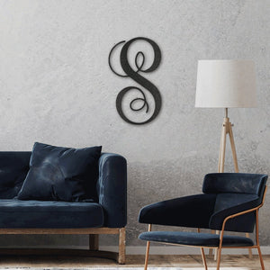 Modern living room with dark blue sofa, armchair, and decorative wall piece.