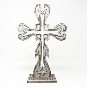 Farmhouse cross styled on mantel creating a warm and peaceful space