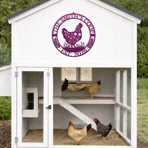 White chicken coop with a pink sign on the door, featuring chickens inside.