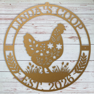 Decorative copper colored metal sign with chicken silhouette and text on a wooden background