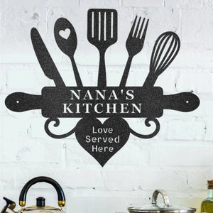 Decorative wall art with kitchen utensils and 'Nana's Kitchen' text on a white brick wall.