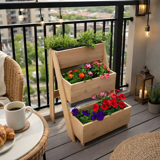Wooden planter with flowers on a balcony with a cup of coffee and pastries.