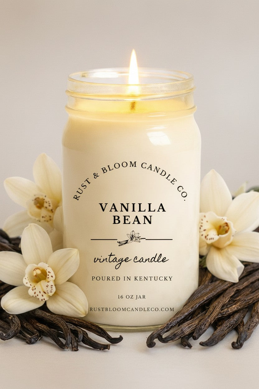 Farmhouse World Vanilla Bean vintage candle in a 16 oz jar, surrounded by vanilla beans and orchids. Creamy vanilla scent.