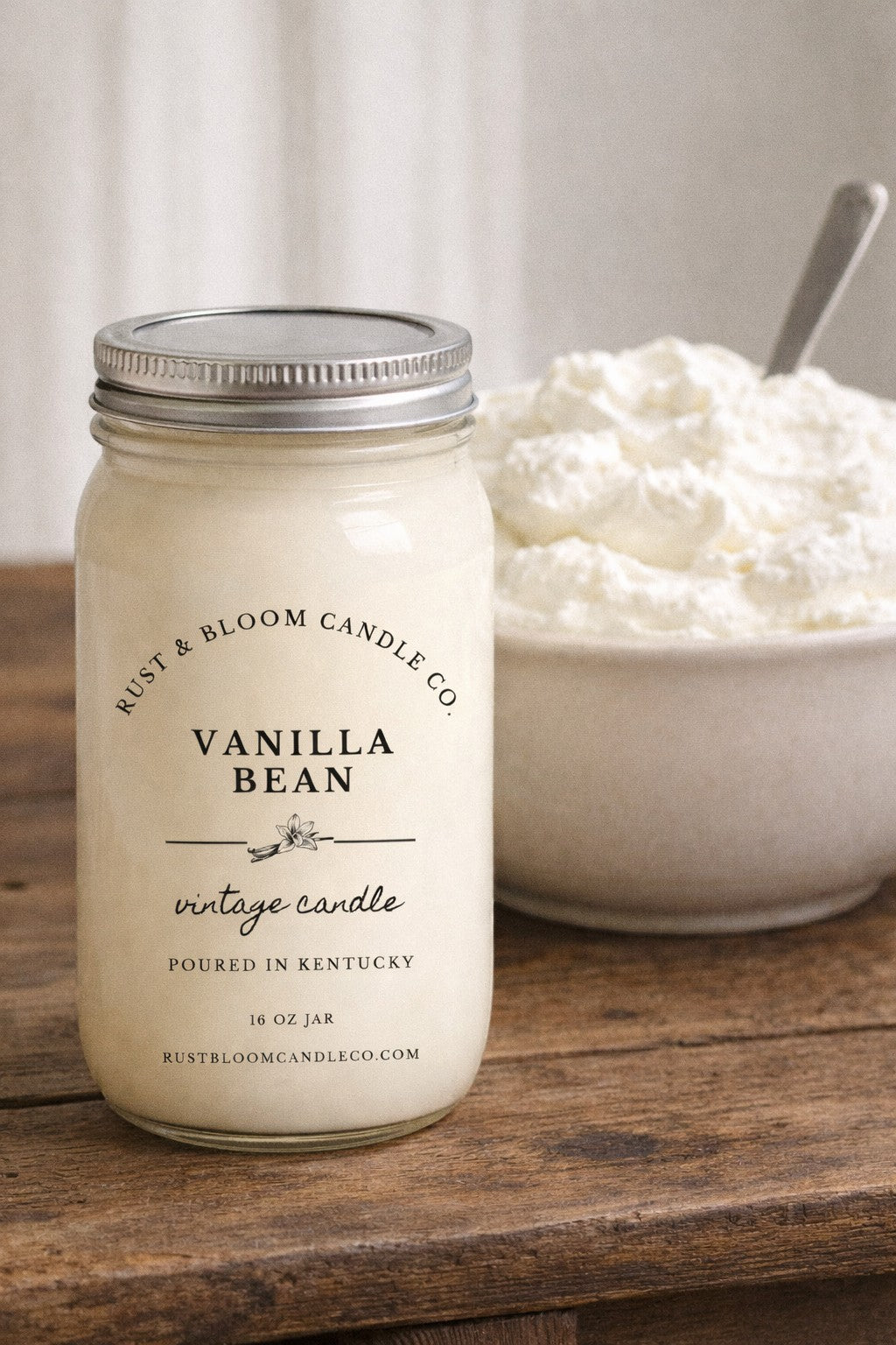 Farmhouse World Vanilla Bean vintage candle in a 16 oz glass jar with a silver lid. Creamy vanilla scent.