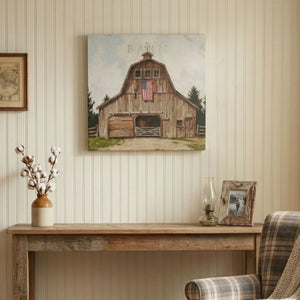 Wooden barn painting on a wall above a wooden console table with decorative items.