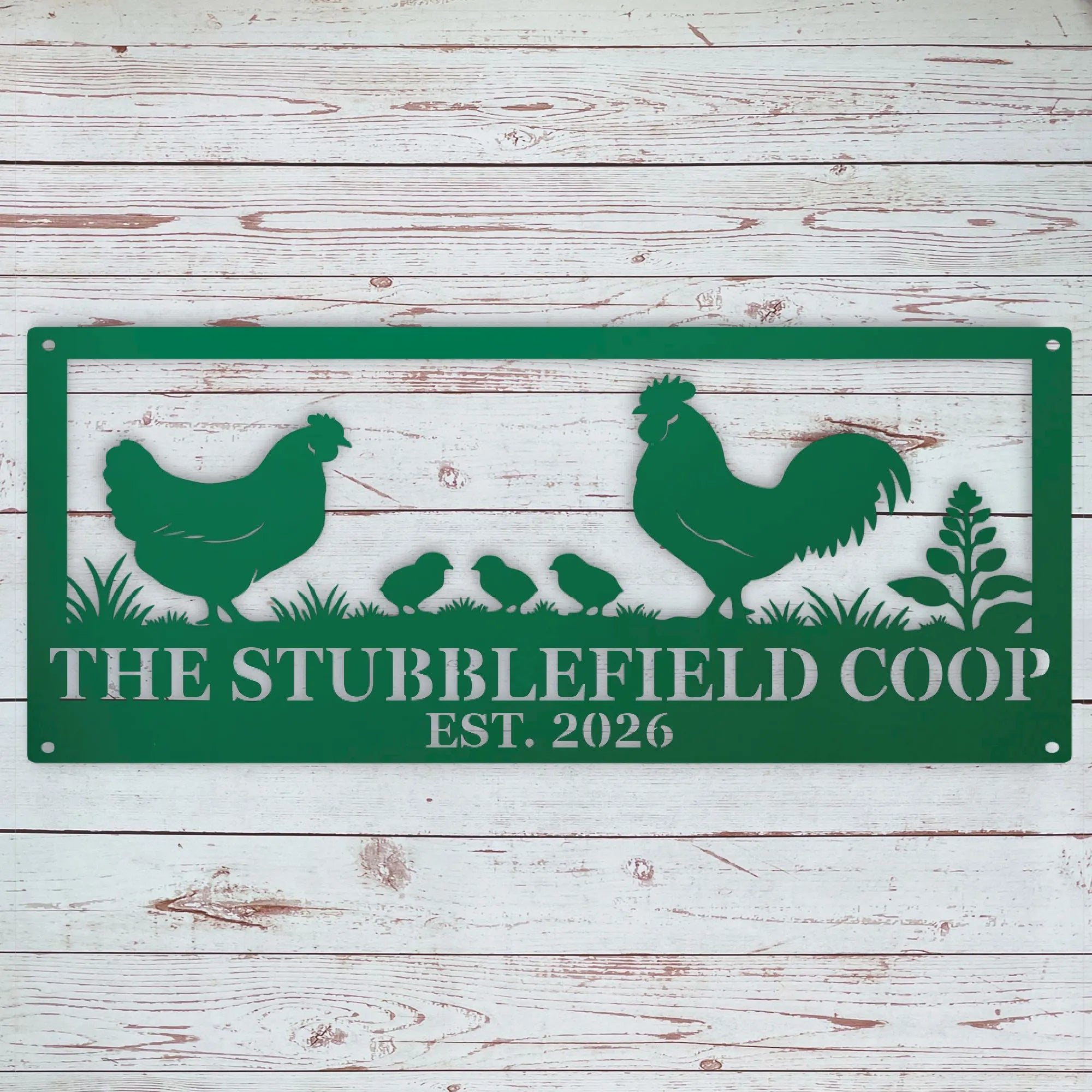 A green metal sign with a silhouette design of a rooster, hen, three chicks, and plants, with the text 'THE STUBBLEFIELD COOP EST. 2026' in white, displayed against a whitewashed wooden plank background.