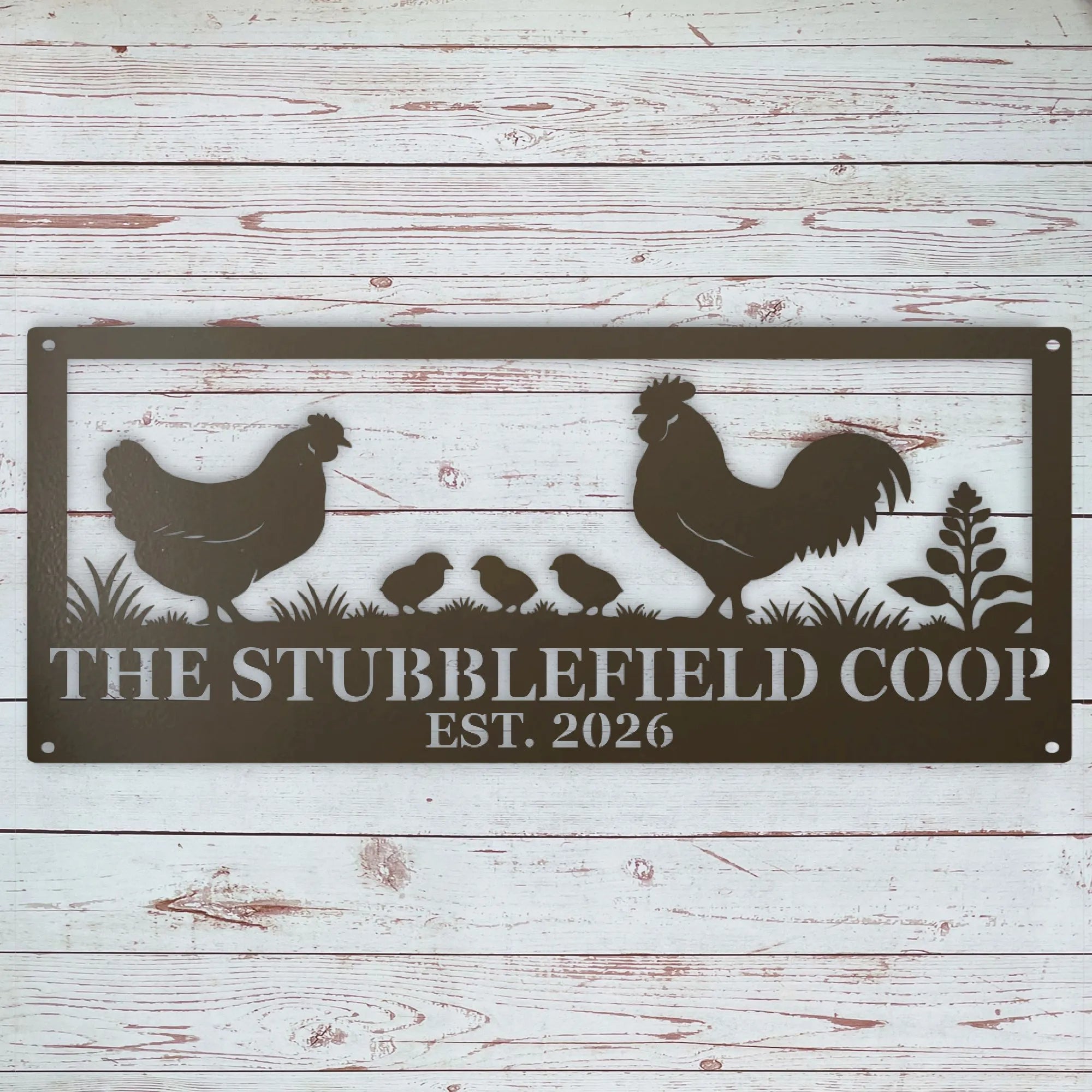 A rectangular metal sign with a silhouette design of a rooster, hen, three chicks, and a plant, with the text 'THE STUBBLEFIELD COOP EST. 2026' on a whitewashed wood plank background.