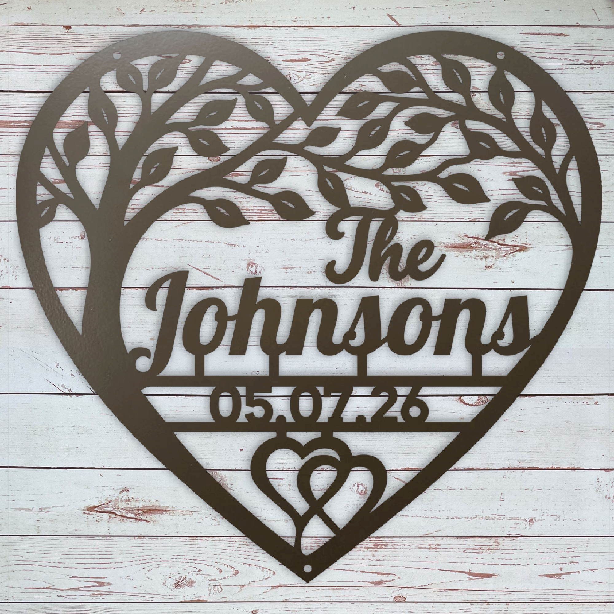 A heart-shaped metal wall sign with a tree silhouette, personalized with the text 'The Johnsons' and the date '05.07.