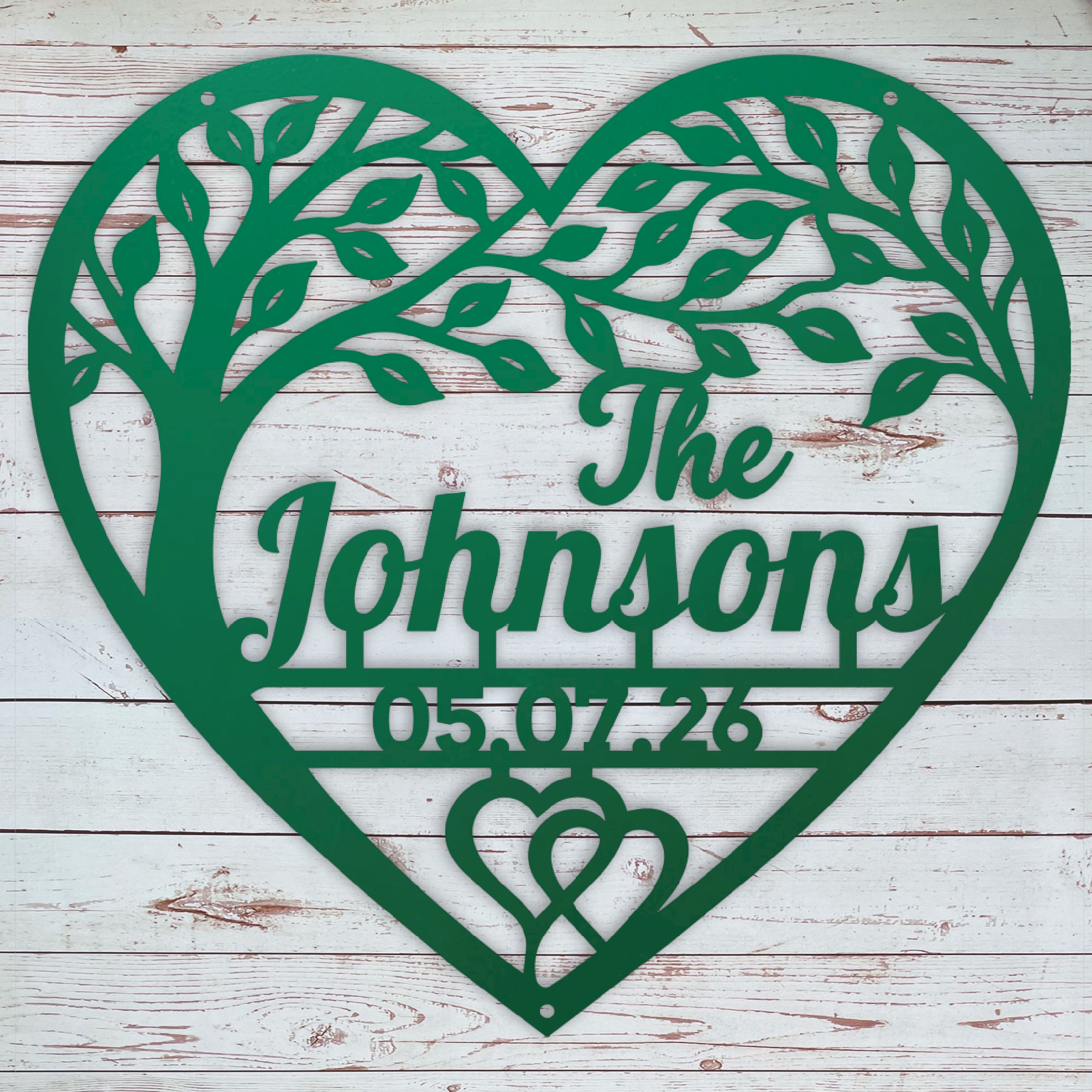 A personalized green metal heart-shaped wall sign featuring a tree silhouette, the text 'The Johnsons', the date '05.07.