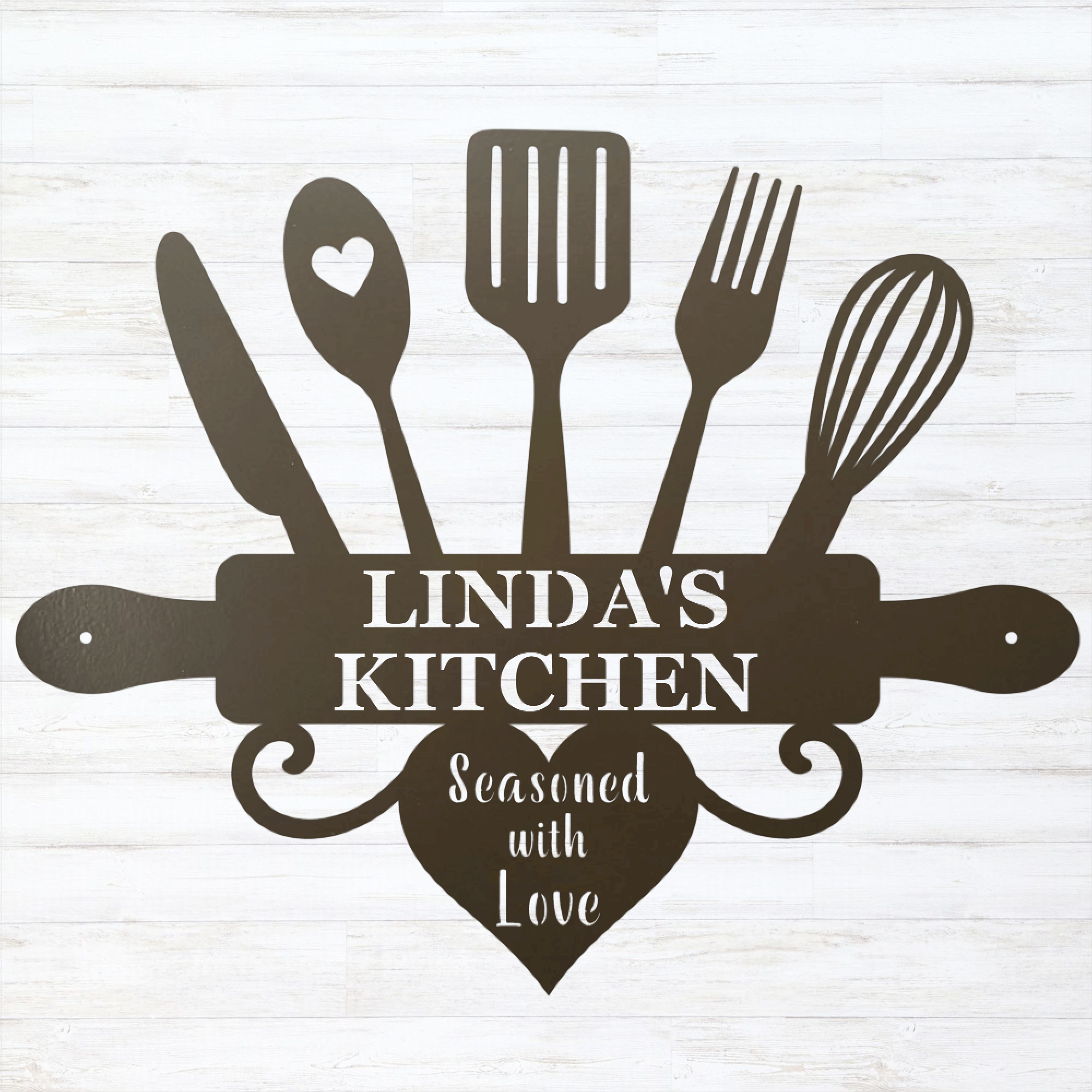 A dark brown metal kitchen-themed wall sign featuring silhouettes of kitchen utensils and a rolling pin with the text 'LINDA'S KITCHEN' and 'Seasoned with Love' on a white wood-plank background.
