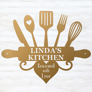 A personalized kitchen-themed graphic or sign featuring gold-colored silhouettes of kitchen utensils and a rolling pin with the text 'LINDA'S KITCHEN' and 'Seasoned with Love' on a white wood-plank background.