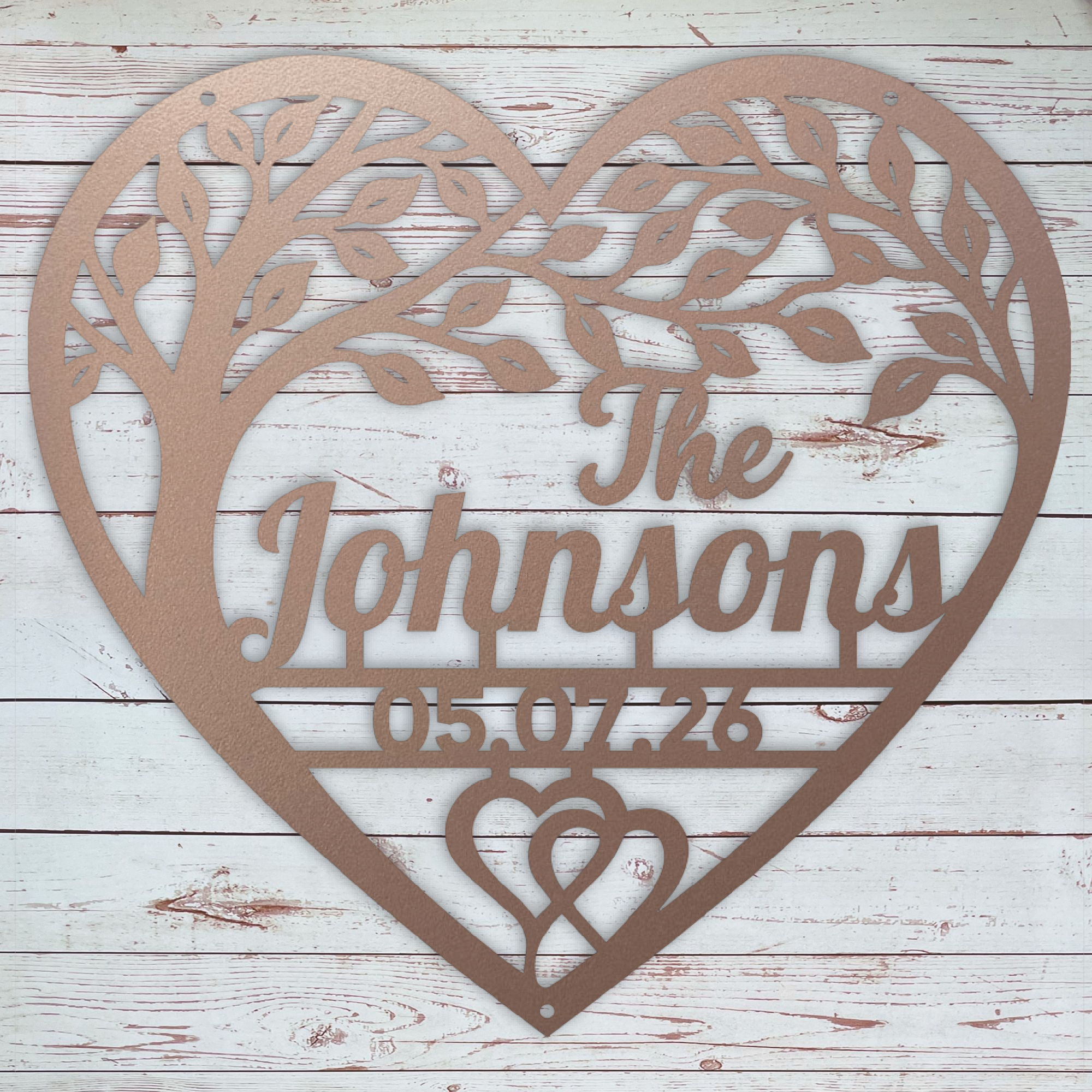 A rose colored heart-shaped personalized metal wall sign with a tree design, featuring a name and the date.